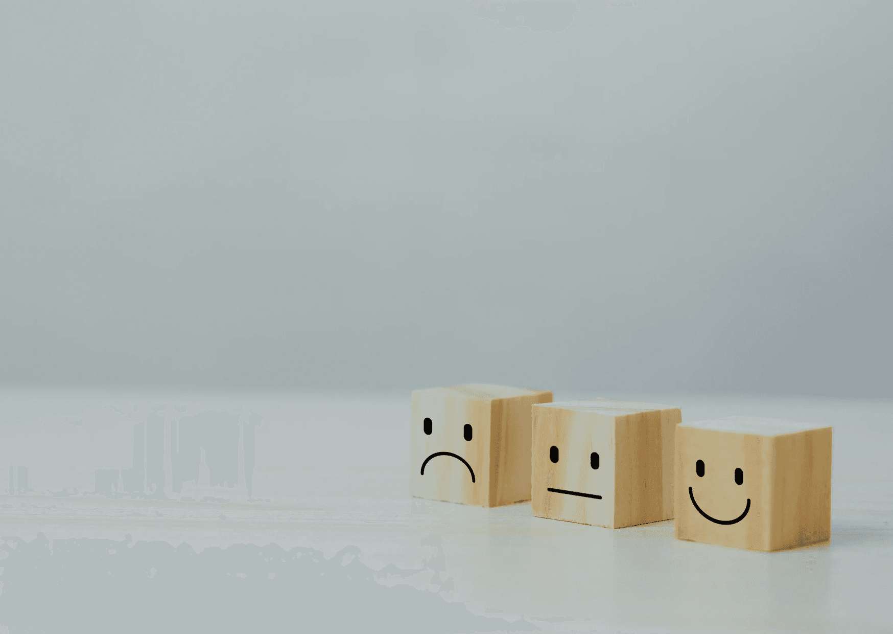 Boxes with smiley faces, one happy, one neutral, one sad